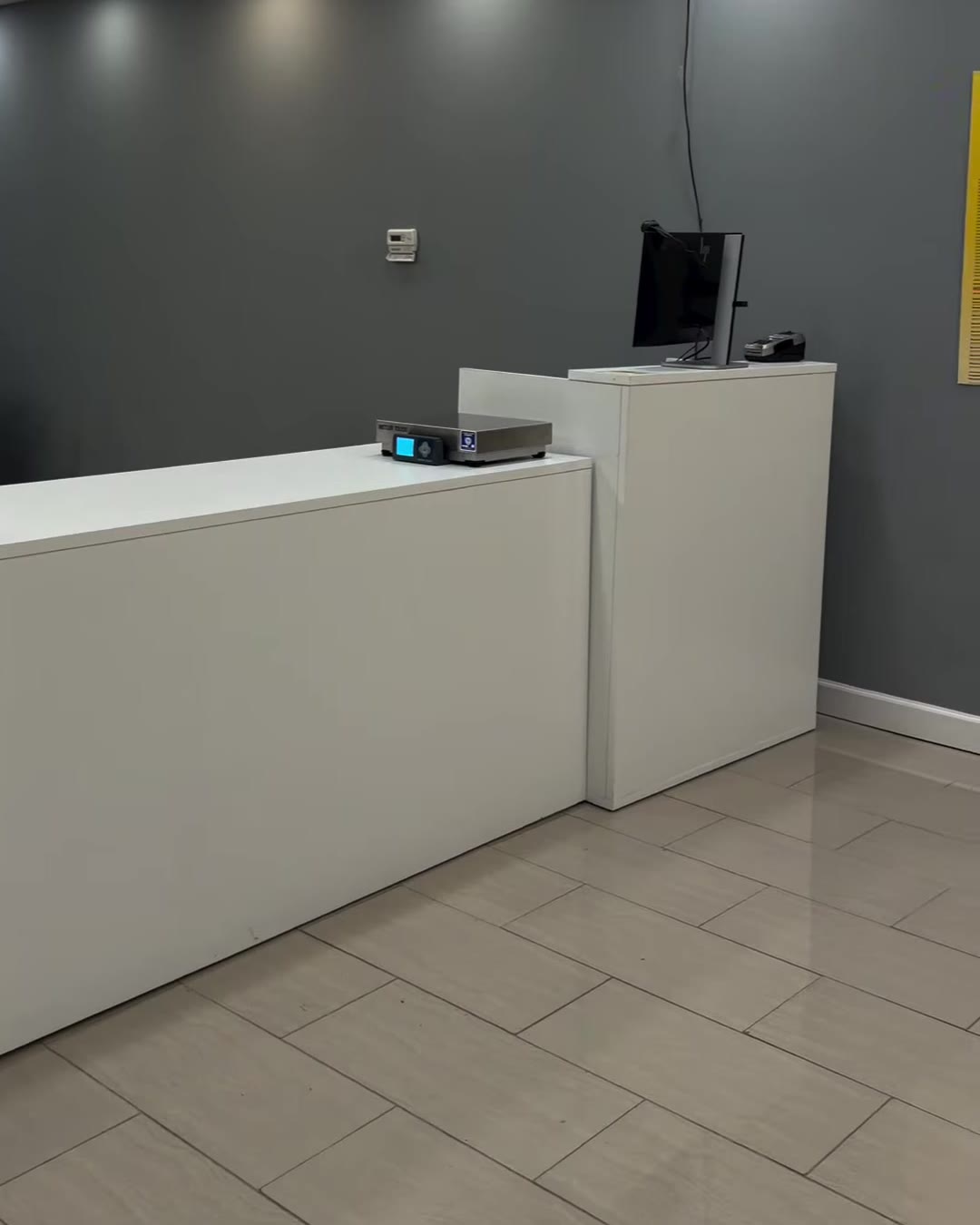 A Cubic Ship counter from the company’s reel: white counter with a parcel scale and a monitor against a grey wall.